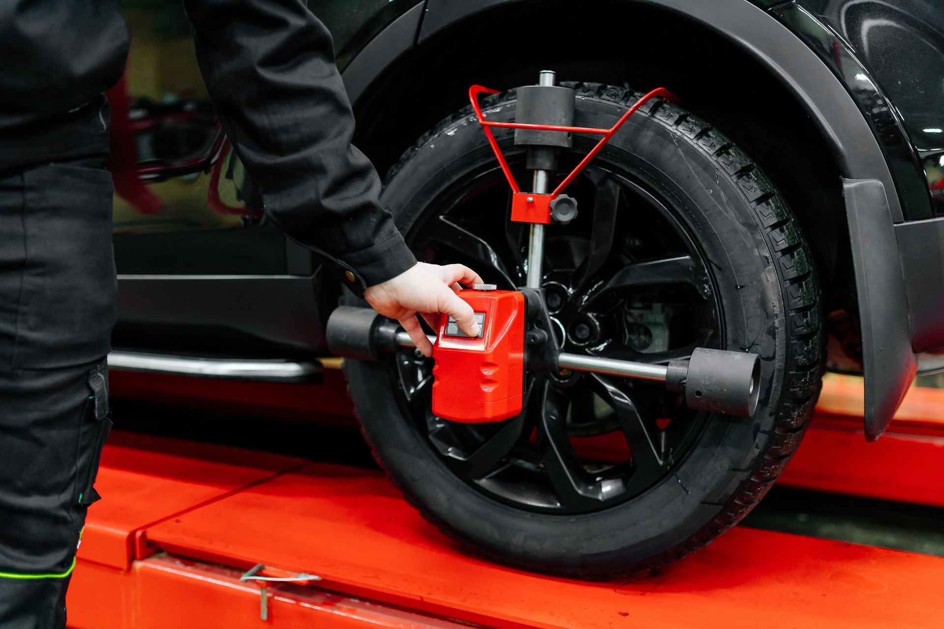 A man is adjusting a tire on a car with a machine.  | Chapmans Front End & Brakes