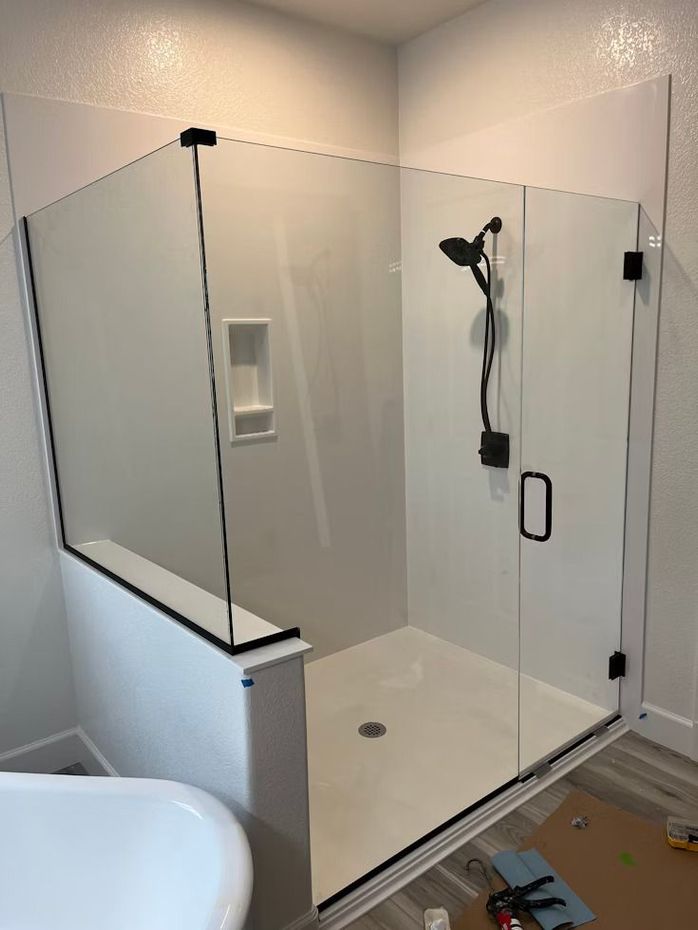 white enclosed shower with black shower handle and fixtures