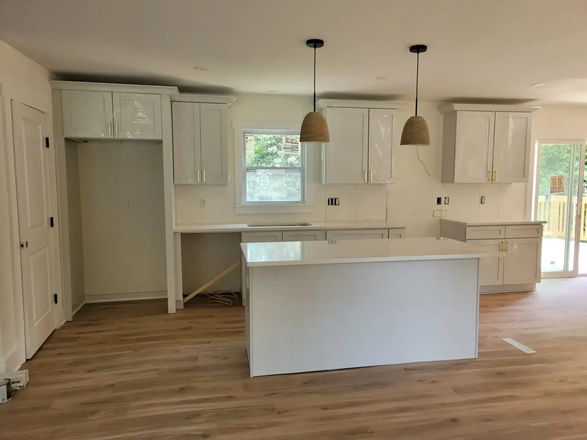 A kitchen with white cabinets and a large island in the middle.