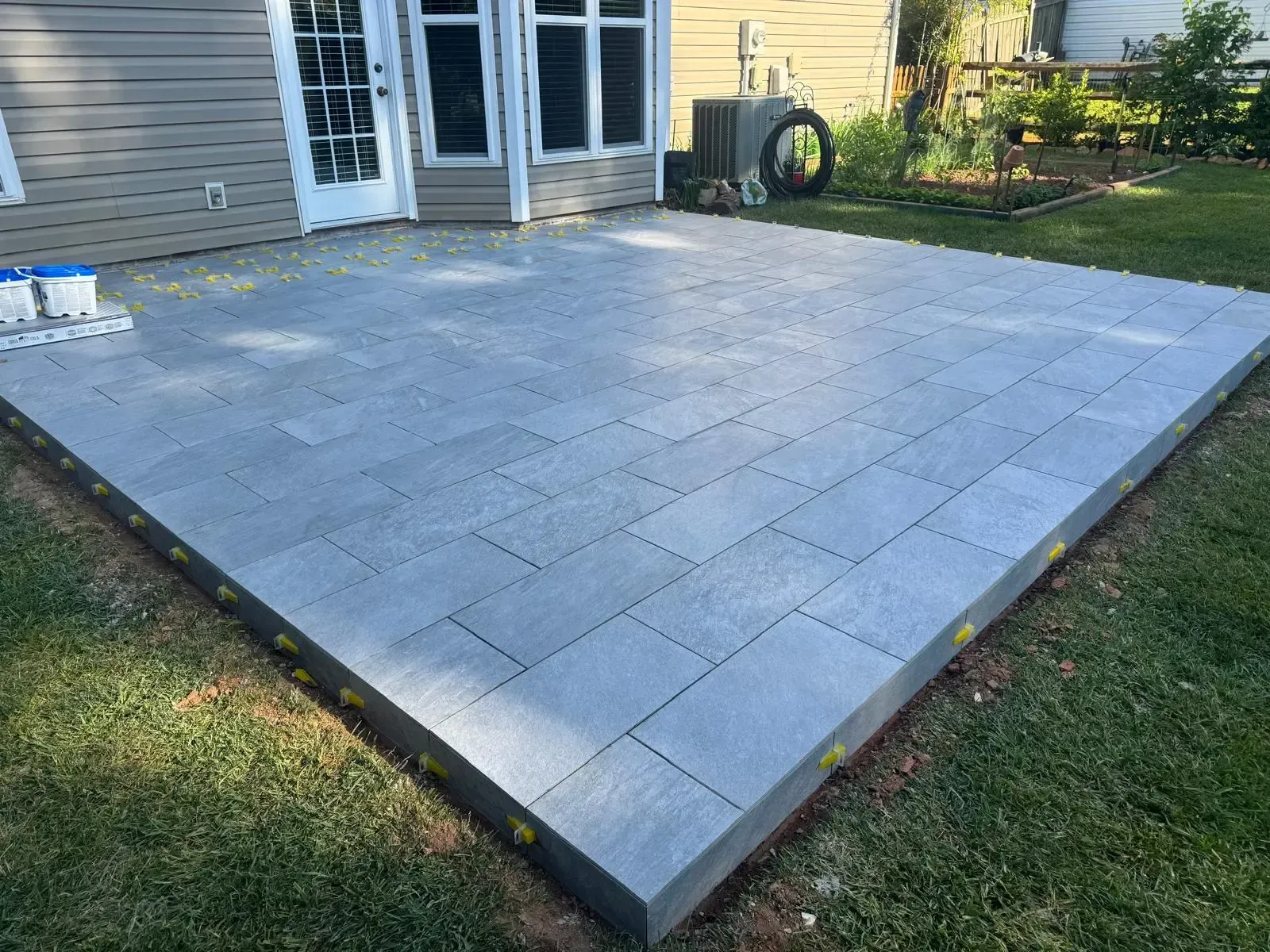 A patio is being built in the backyard of a house.