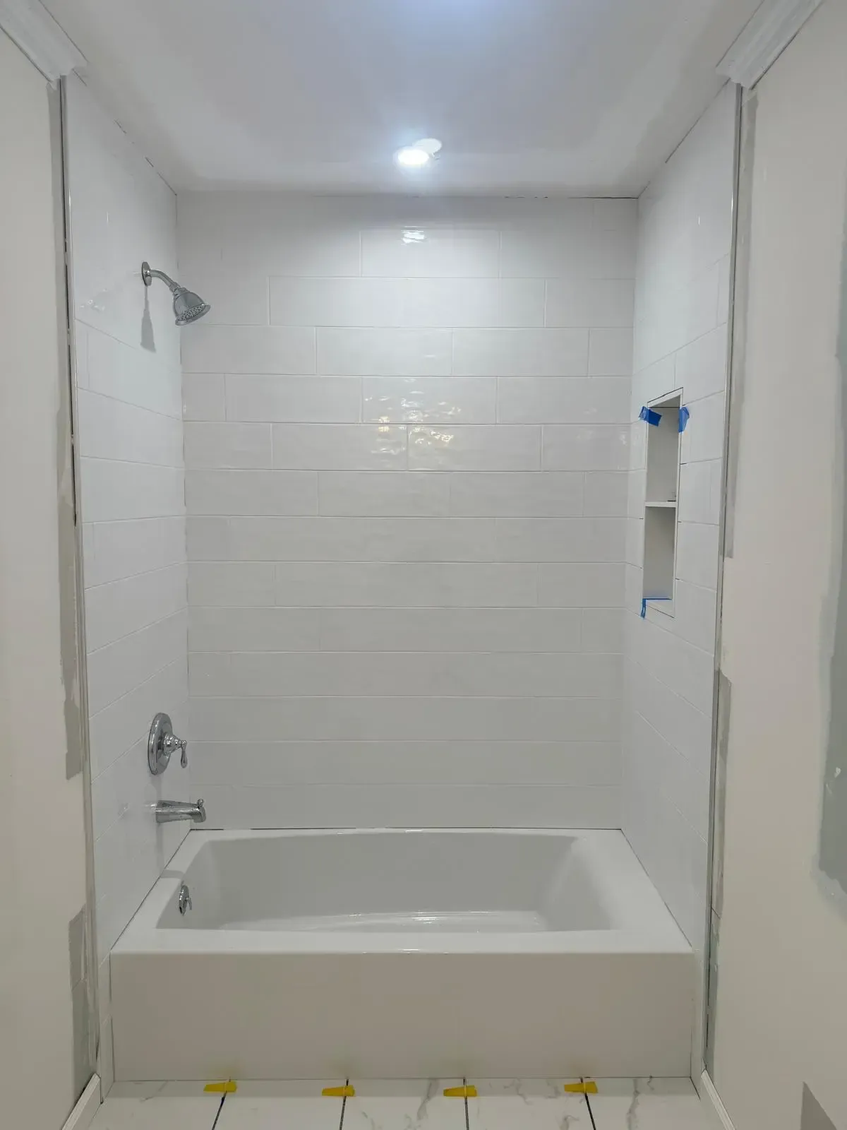 A bathroom with a bathtub and shower under construction.
