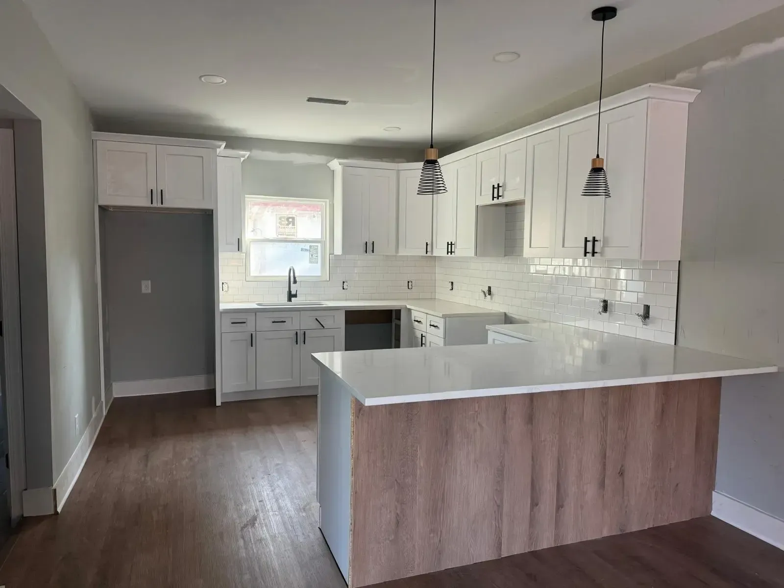 A kitchen with white cabinets and a large island in the middle.