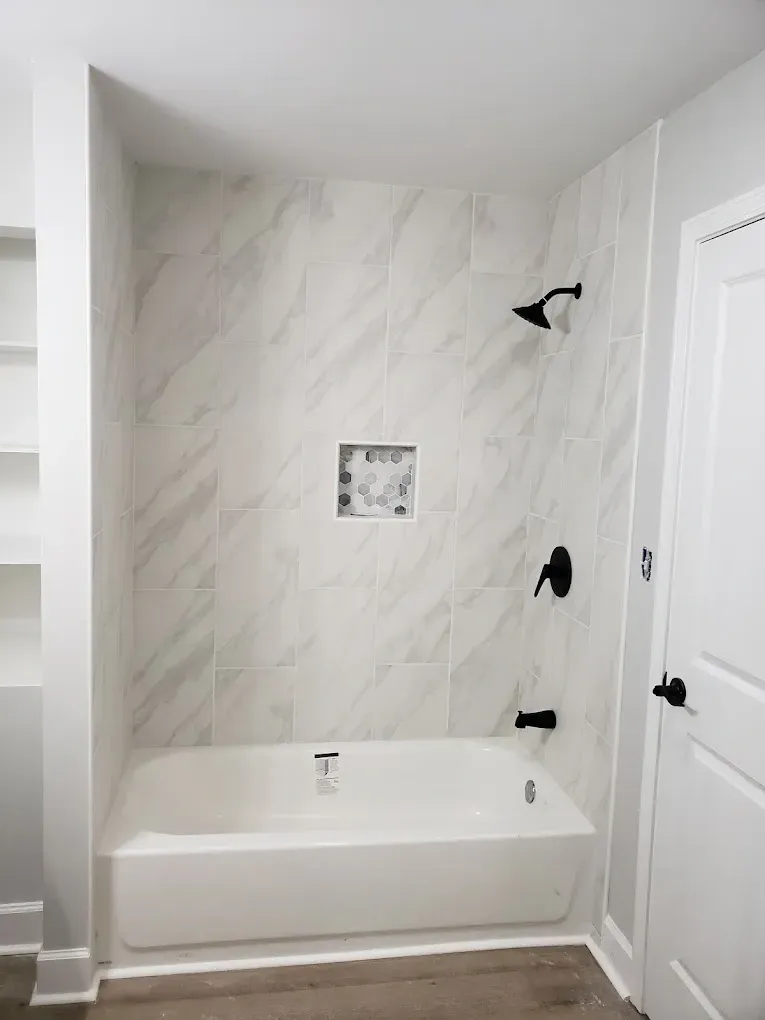 A bathroom with a bathtub and a shower.