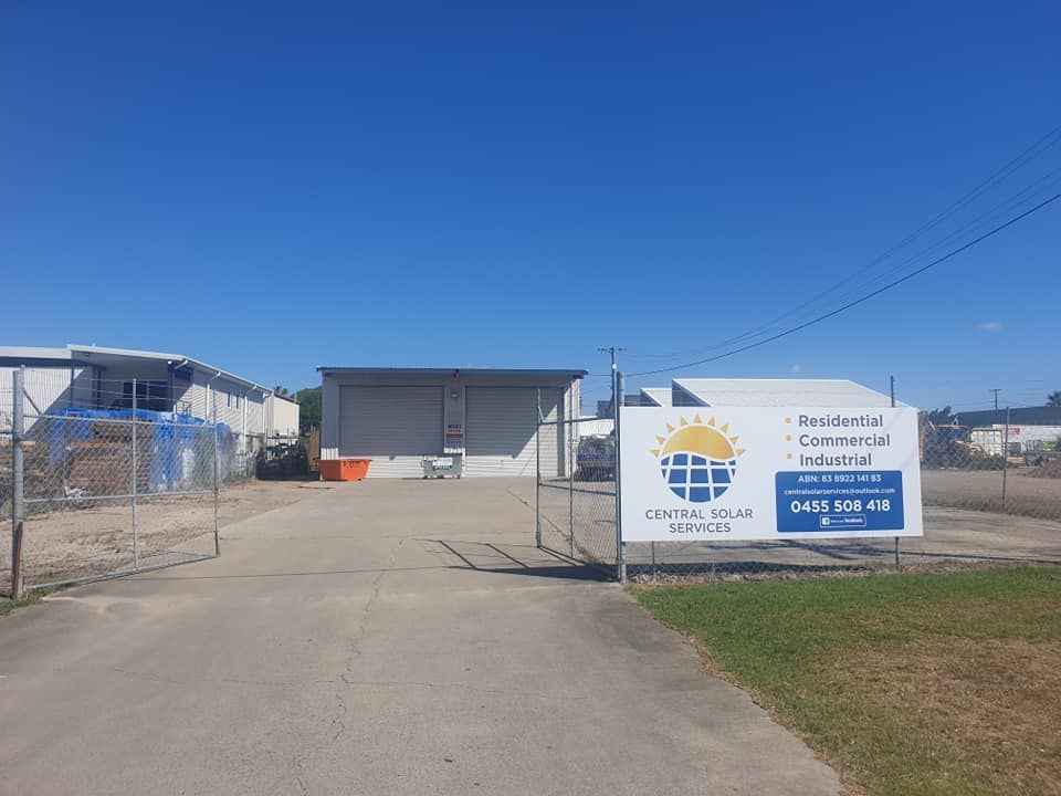 A Large White Sign Is Sitting on The Side of A Road in Front of A Building — Central Solar Services in Garbutt, QLD