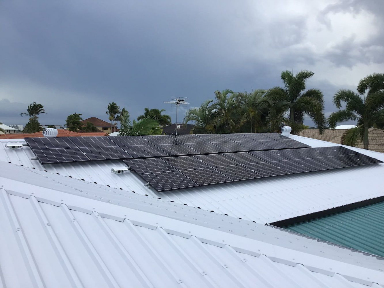 A Roof with Solar Panels on It and A Pool in The Background — Central Solar Services in Garbutt, QLD