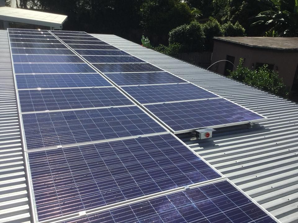 A Row of Solar Panels Are Sitting on Top of A Roof — Central Solar Services in Garbutt, QLD