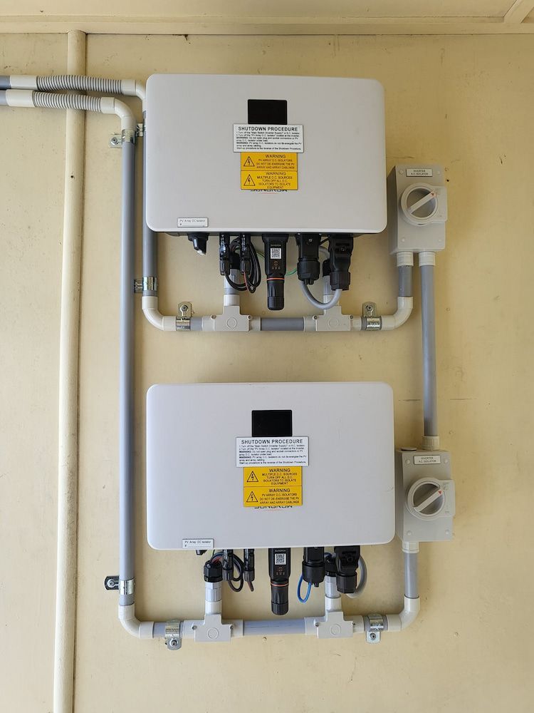 Two Solar Panels Are Mounted on A Wall— Central Solar Services in Garbutt, QLD