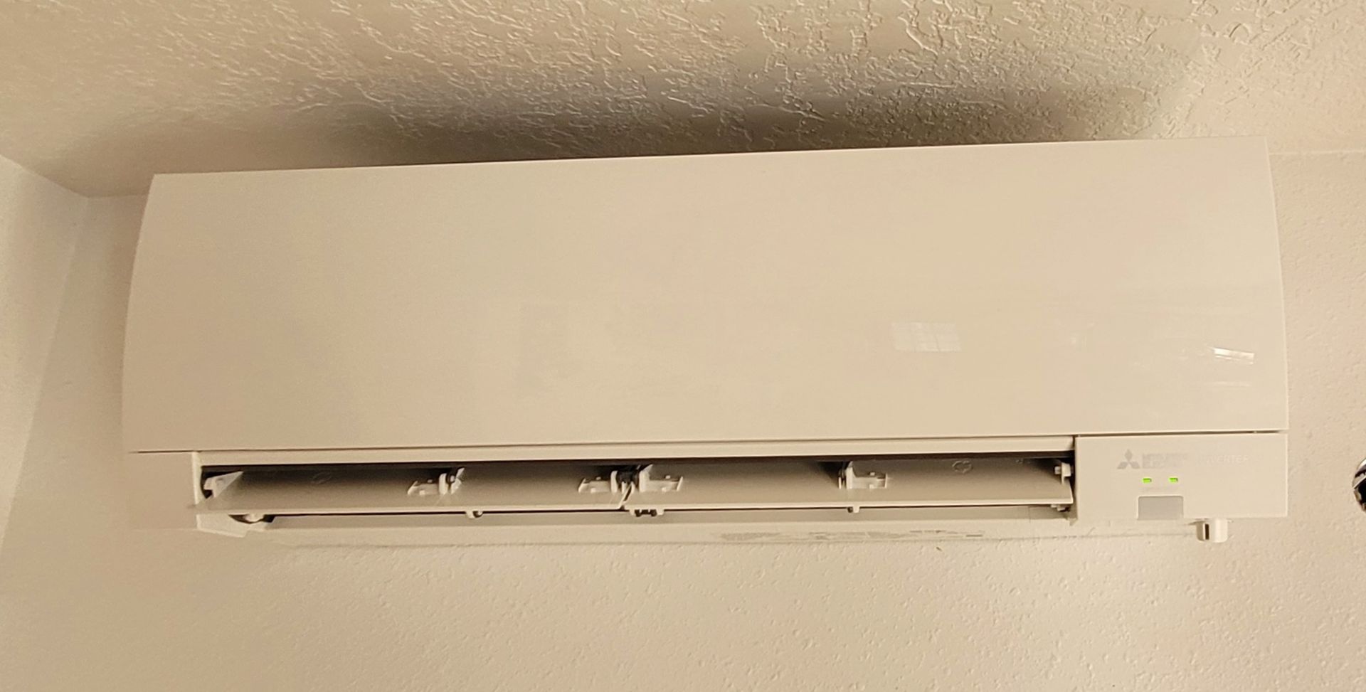 Heavy Metal HVAC LLC - White wall-mounted air conditioner, mounted on a white wall.