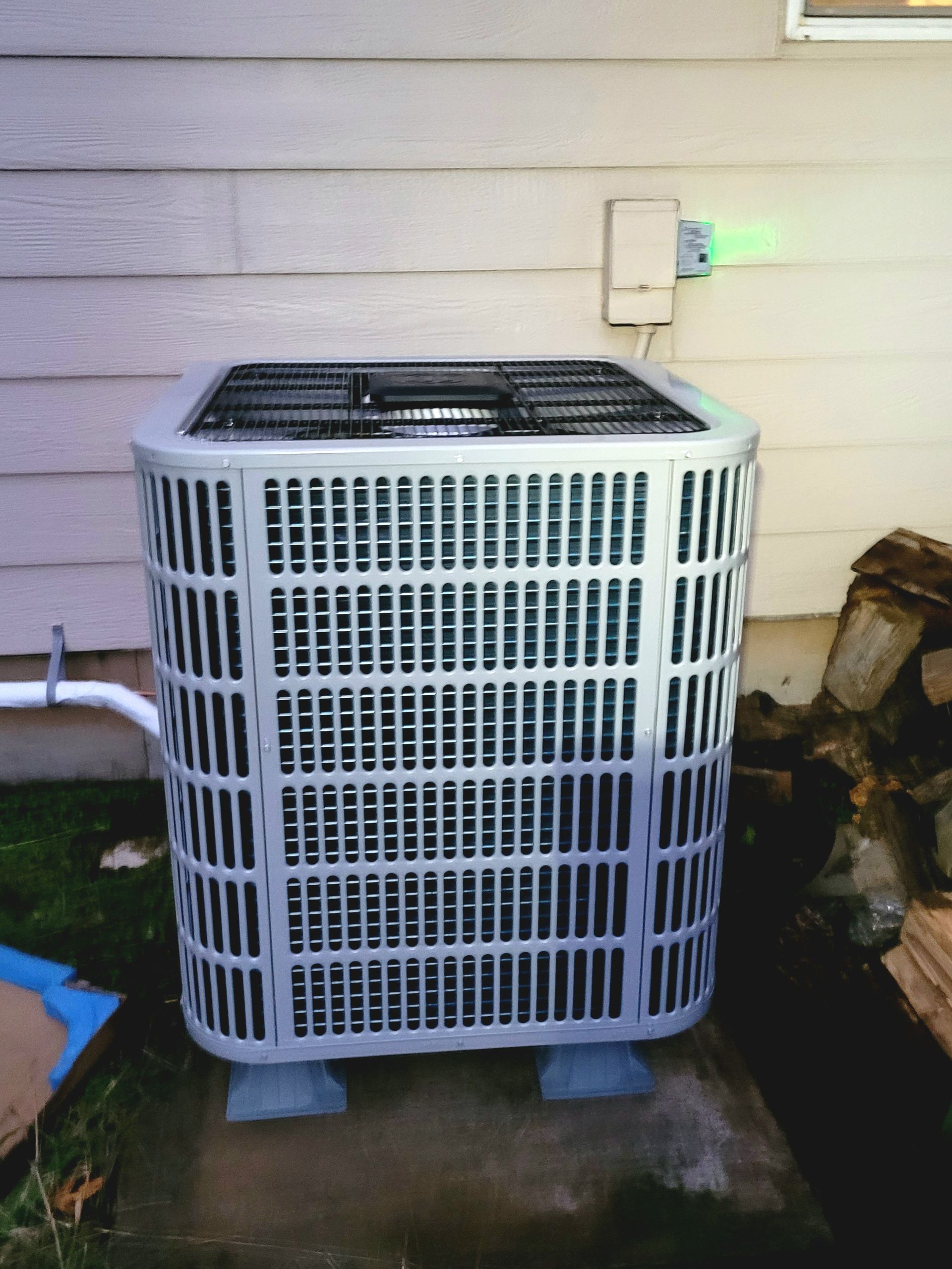 a white air conditioner is sitting outside of a house