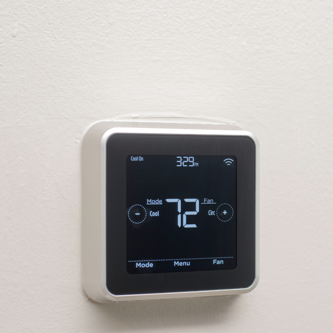 A square, digital thermostat with a black screen displaying the temperature as 72 degrees Fahrenheit.
