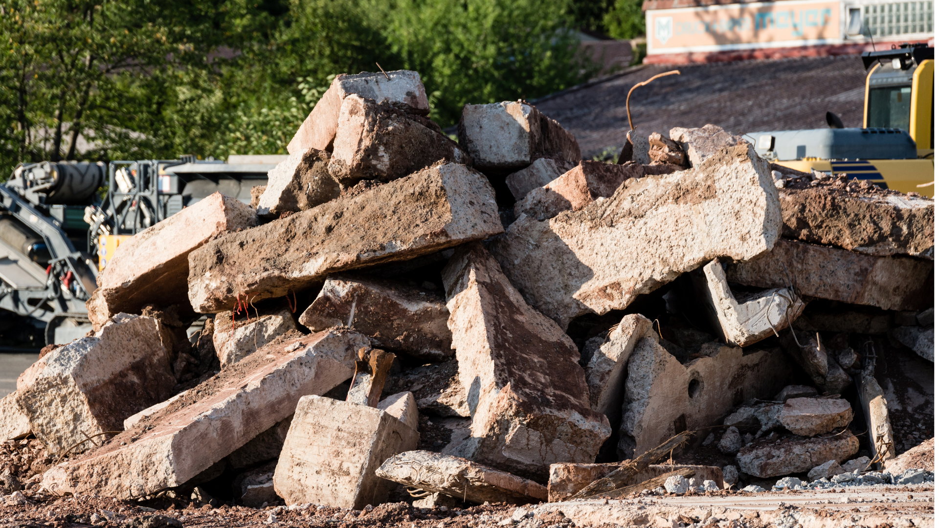 a pile of concrete blocks on a construction site with a bulldozer in the background .