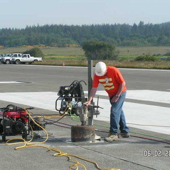 a man is kneeling on the floor using a vacuum cleaner .