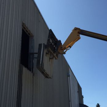 a crane is lifting a sign on the side of a building .