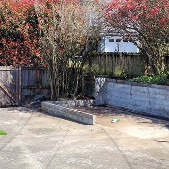 a concrete ramp in a parking lot next to a wooden fence .