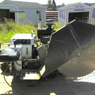 a machine is sitting in front of a building that says for rent