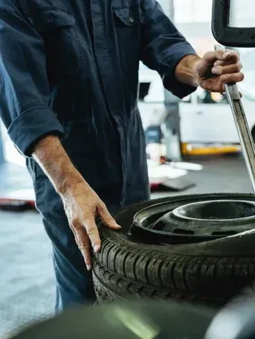 Tim Ledford Towing and Auto Repair Service image of auto repair technician with tire repair