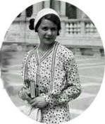 A black and white photo of a woman in a polka dot dress holding a book.