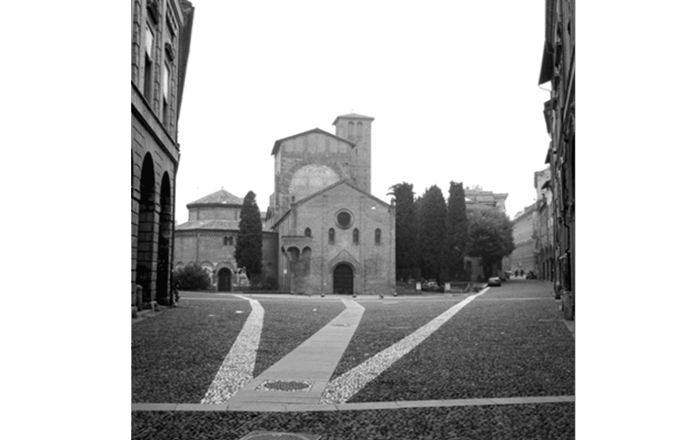 A black and white photo of a church surrounded by buildings