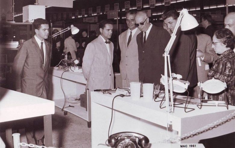 A group of people looking at a table with a phone on it