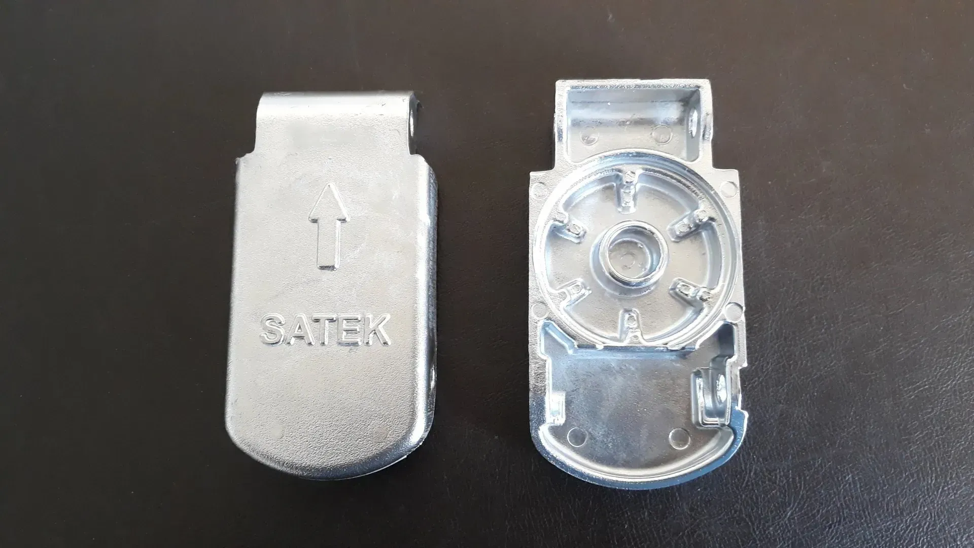 Due parti in metallo argentato, una con la scritta