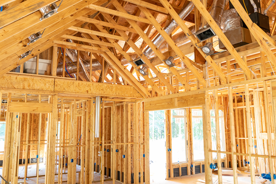 the inside of a house that is being built with wooden beams .