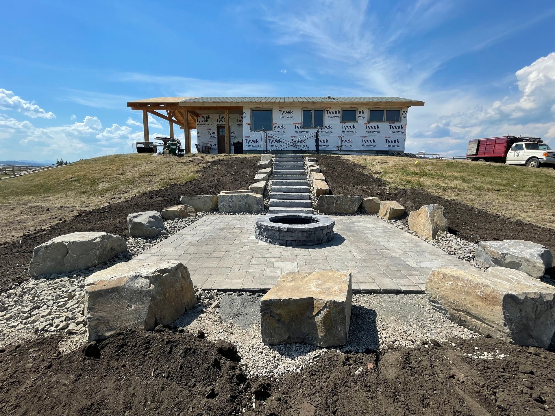 stone stairs down to built in fire pit and patio