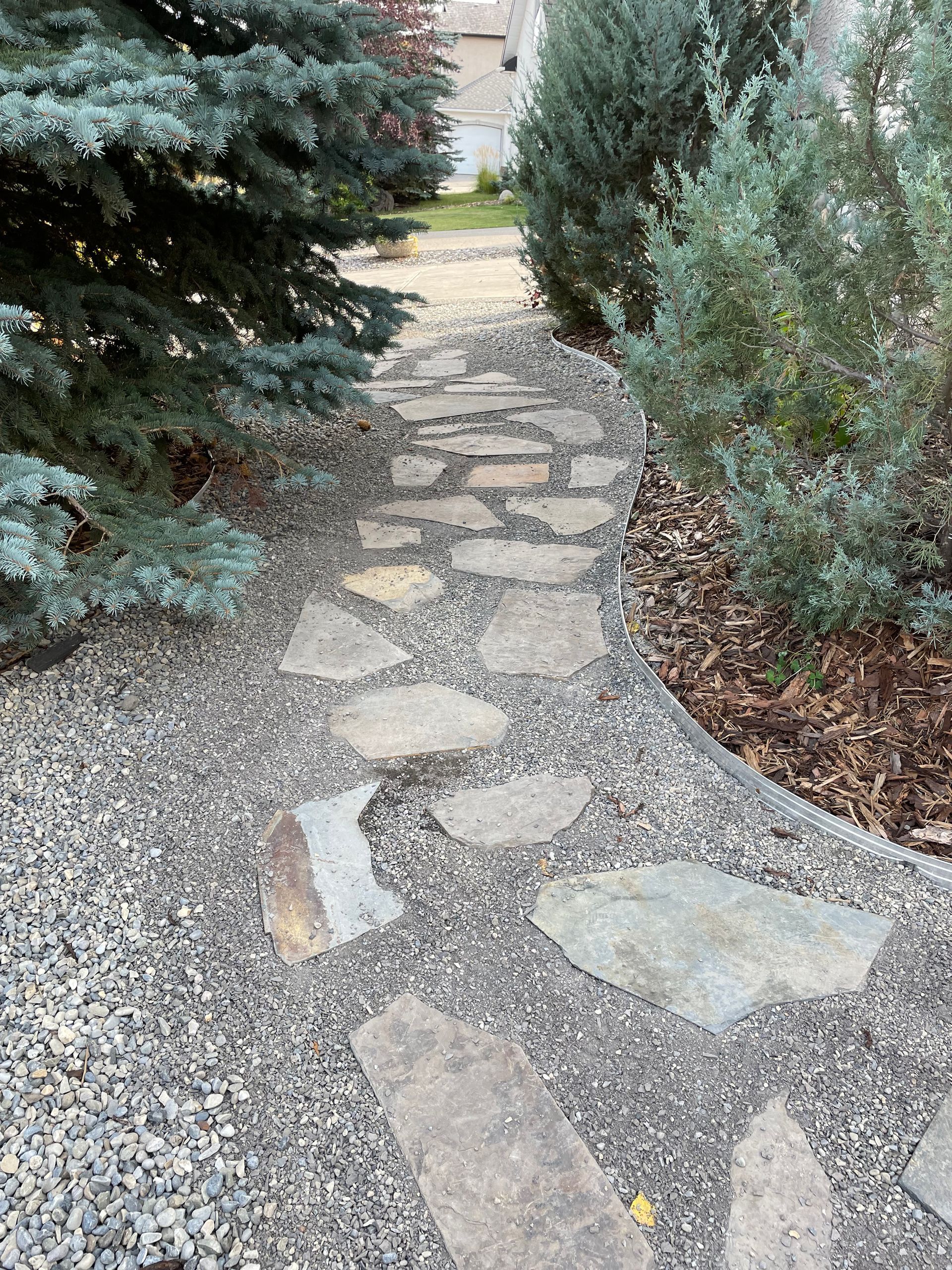 stone pathway with mulch gardens beside