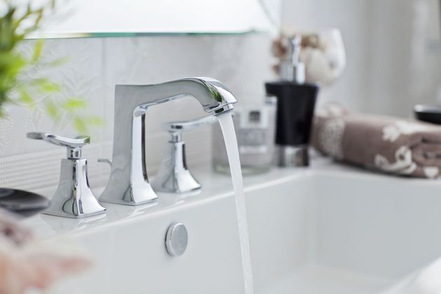 A bathroom sink with water running from the faucet.