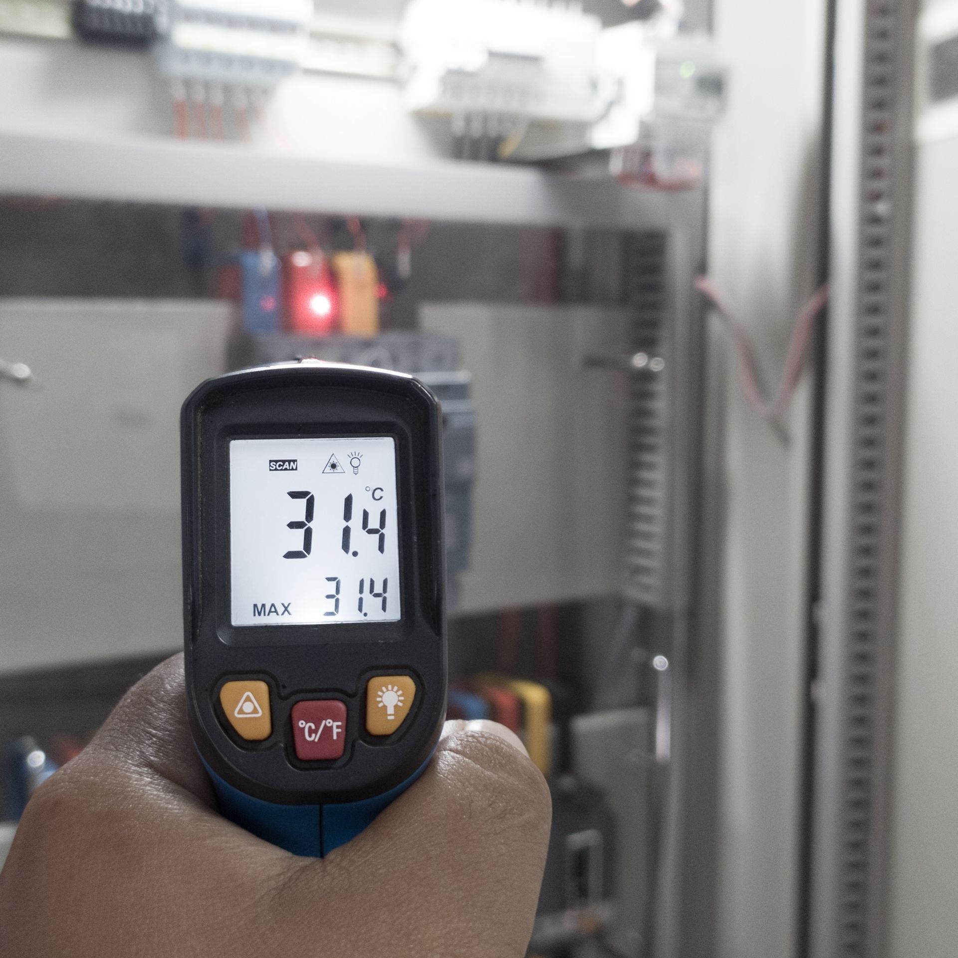 A hand is holding a thermometer that reads 31.4 degrees celsius