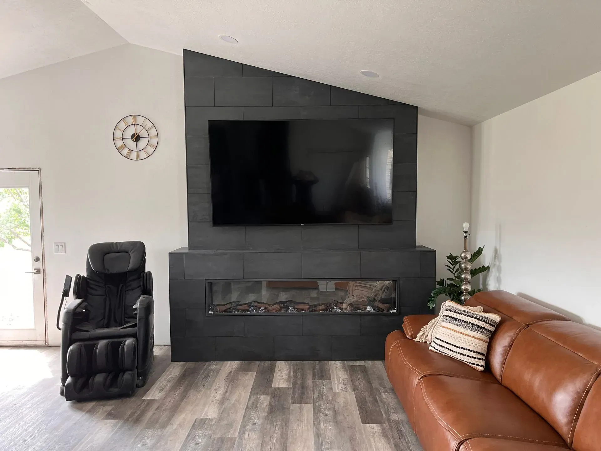 Hallway with stack of cardboard boxes, desk visible through window, blinds, wood trim, and a door on the left.