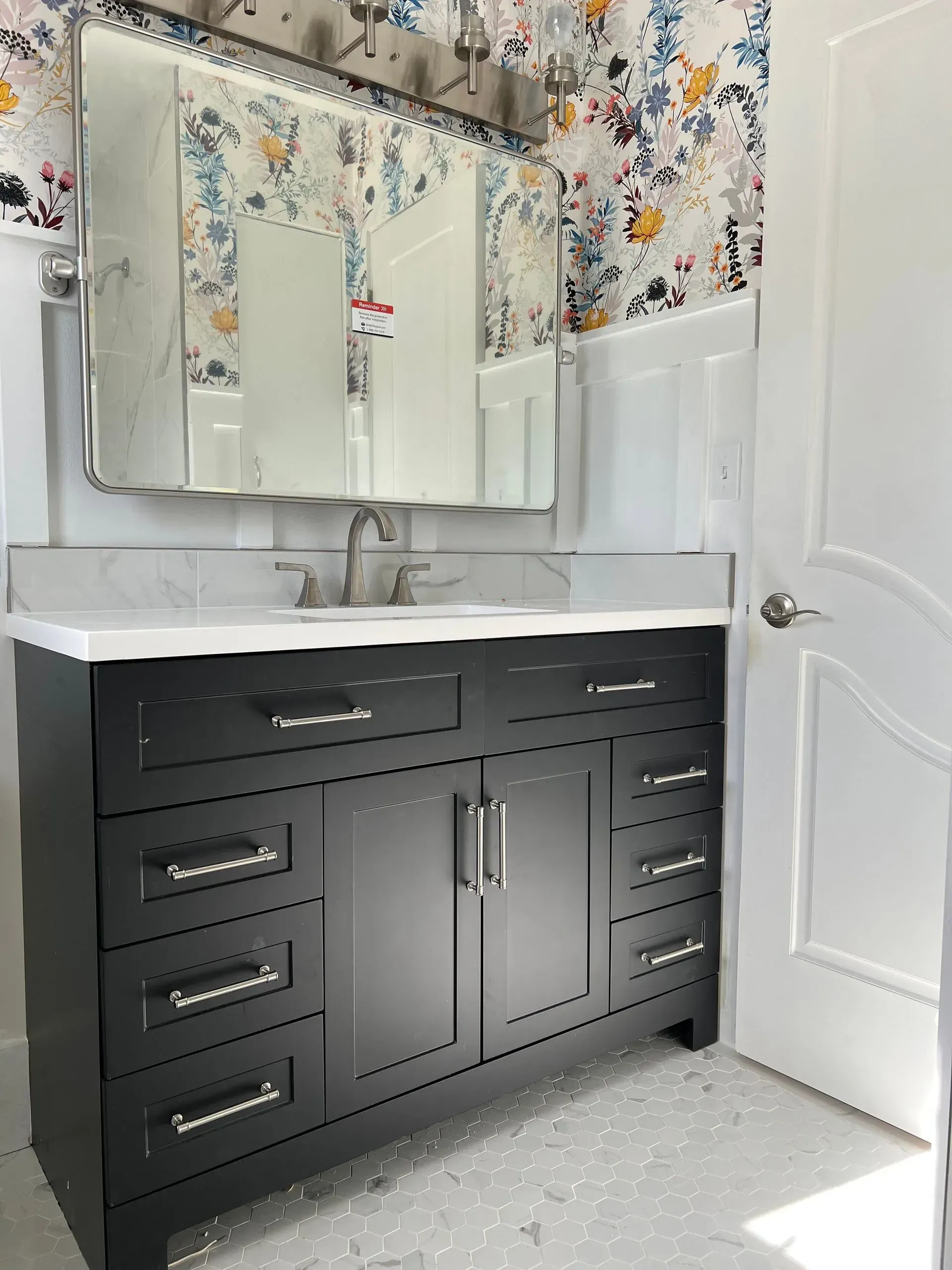 A gray tiled shower with black fixtures and a window.