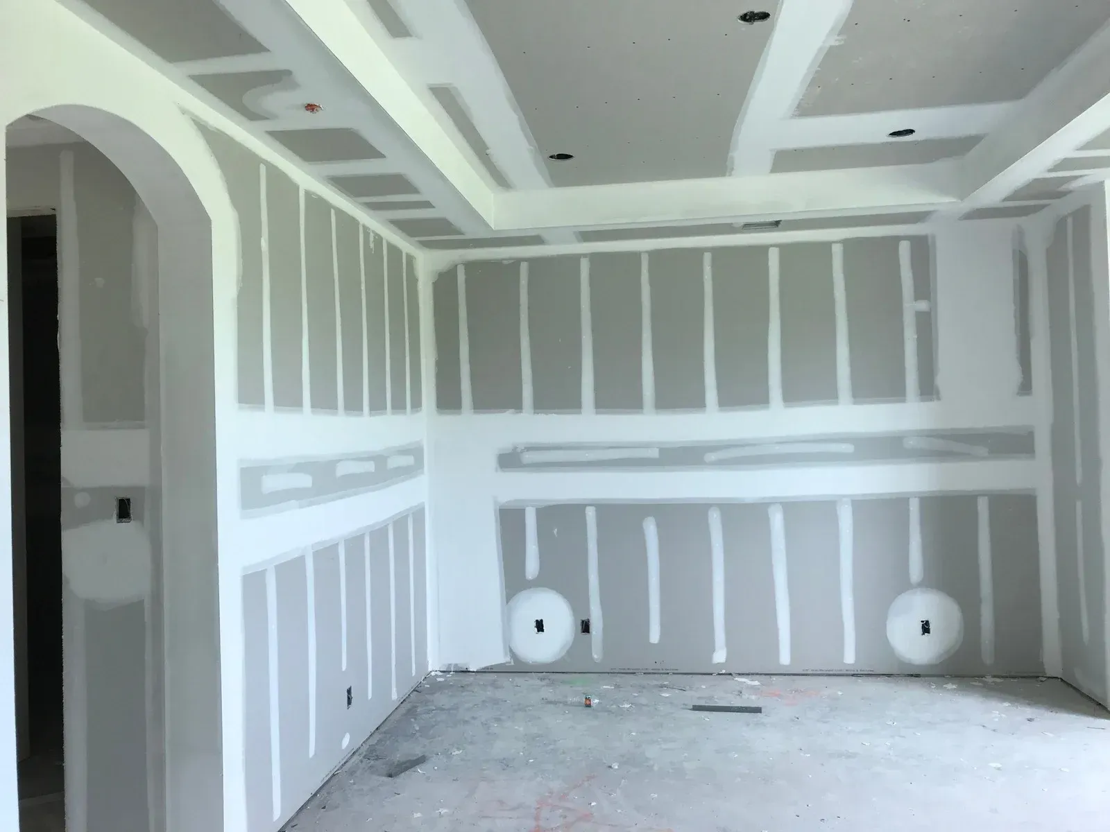 Interior room with exposed drywall on walls and ceiling; construction phase.