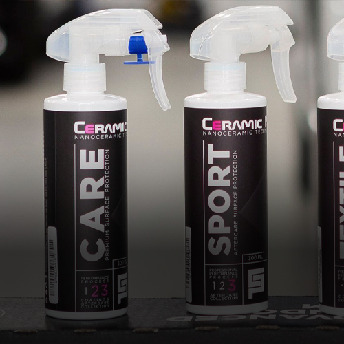 Two bottles of Ceramic Pro nanoceramic spray, labeled "CARE" and "SPORT," stand side-by-side on a dark surface.