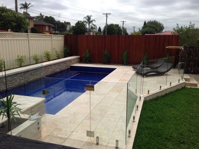 A large swimming pool with a glass fence around it