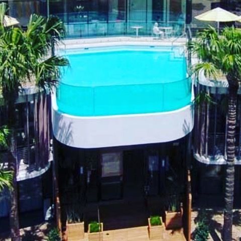 An aerial view of a large swimming pool surrounded by palm trees