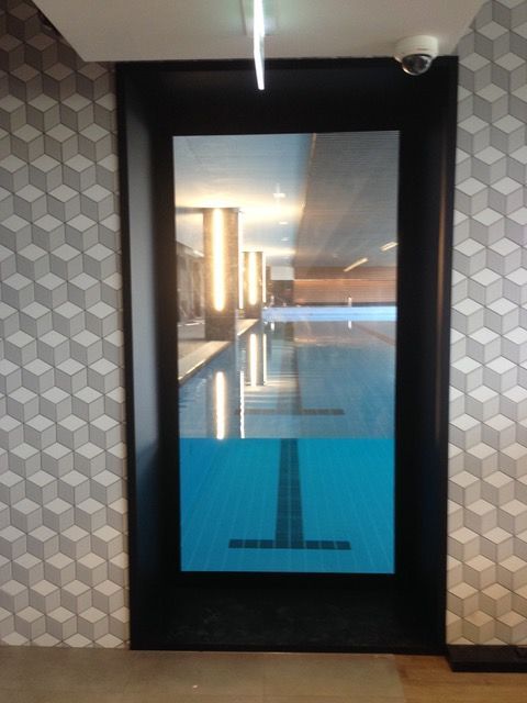 A picture of a swimming pool behind a glass door