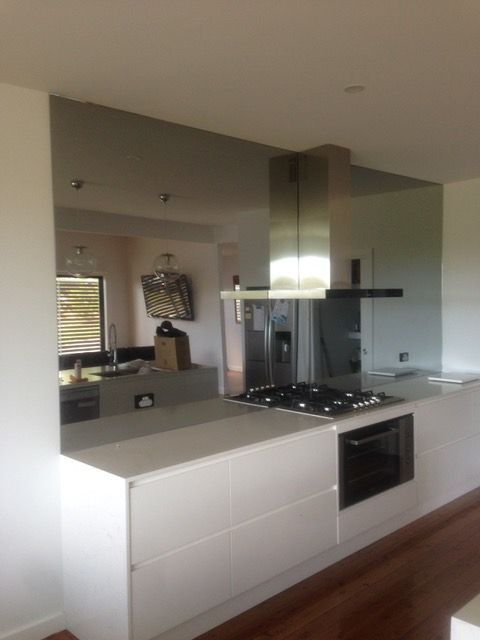 A kitchen with white cabinets and a stove top oven
