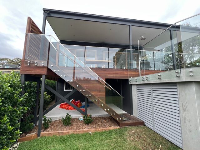 A house with a glass railing and stairs leading up to the second floor
