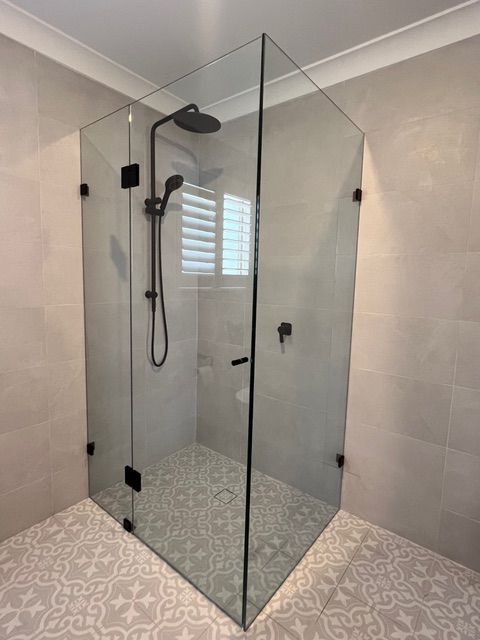 A bathroom with a shower stall and a shower head.