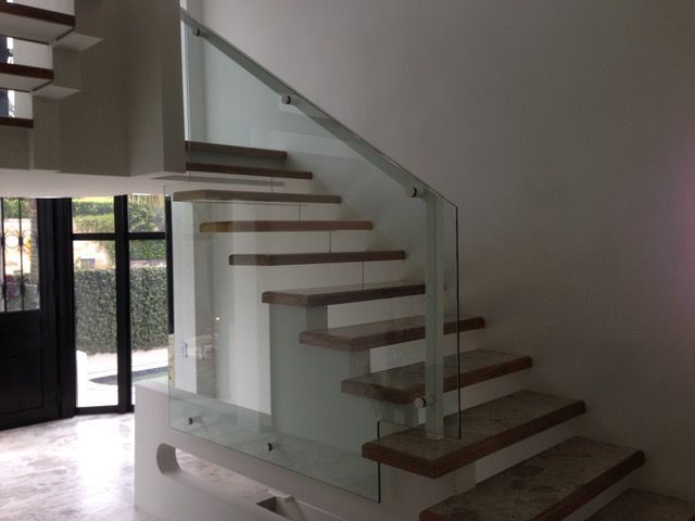 A staircase with a glass railing and wooden steps