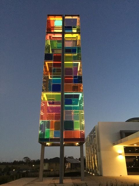A tall building with a colorful tower in front of it