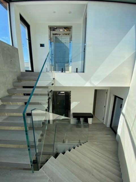 A staircase in a house with a glass railing