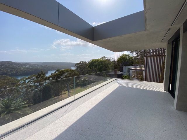 A balcony with a view of a body of water and trees.