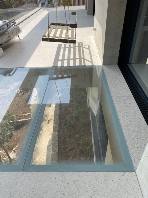 A glass floor with a reflection of a building in it