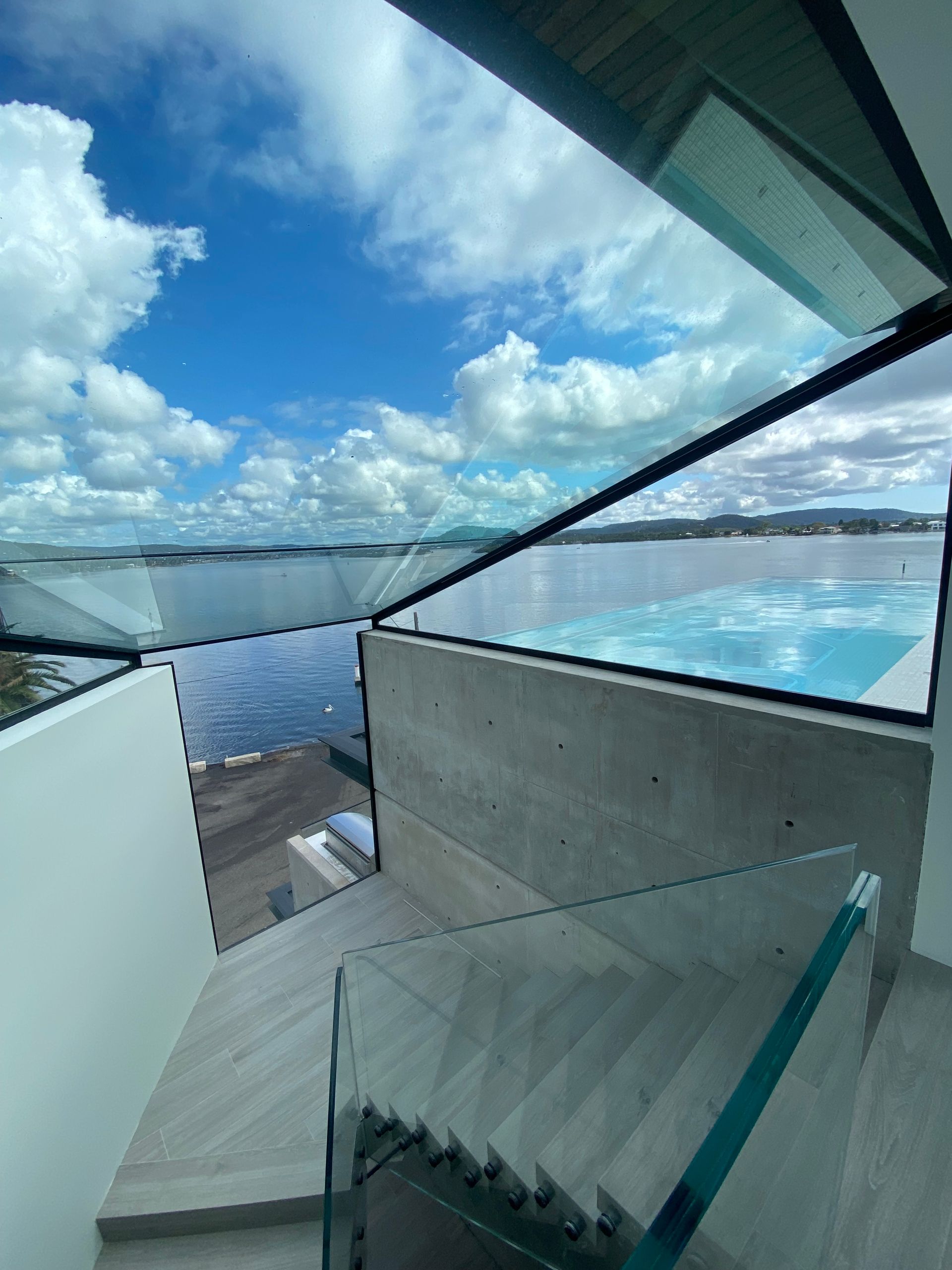 Stairs leading up to a swimming pool with a view of the ocean