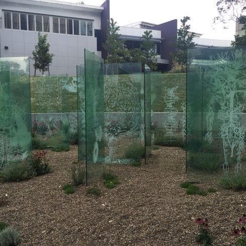 A building with a lot of windows is behind a glass fence