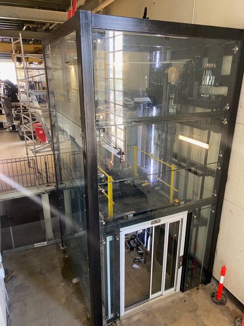 A large glass elevator is being built in a building.