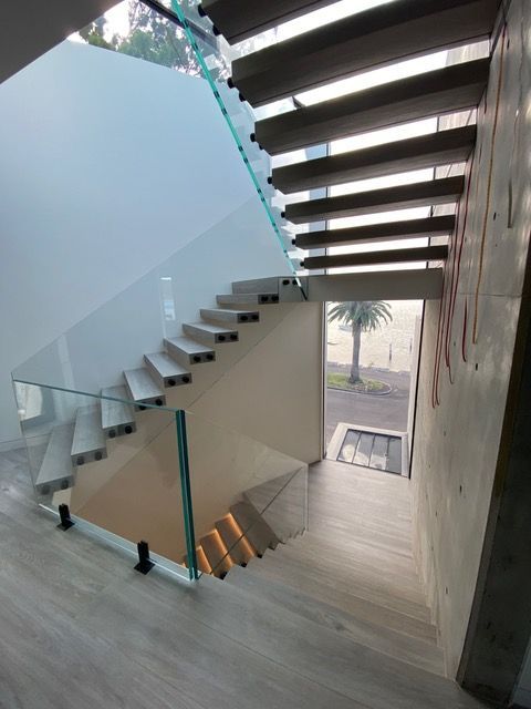 A staircase with a glass railing leading up to the second floor