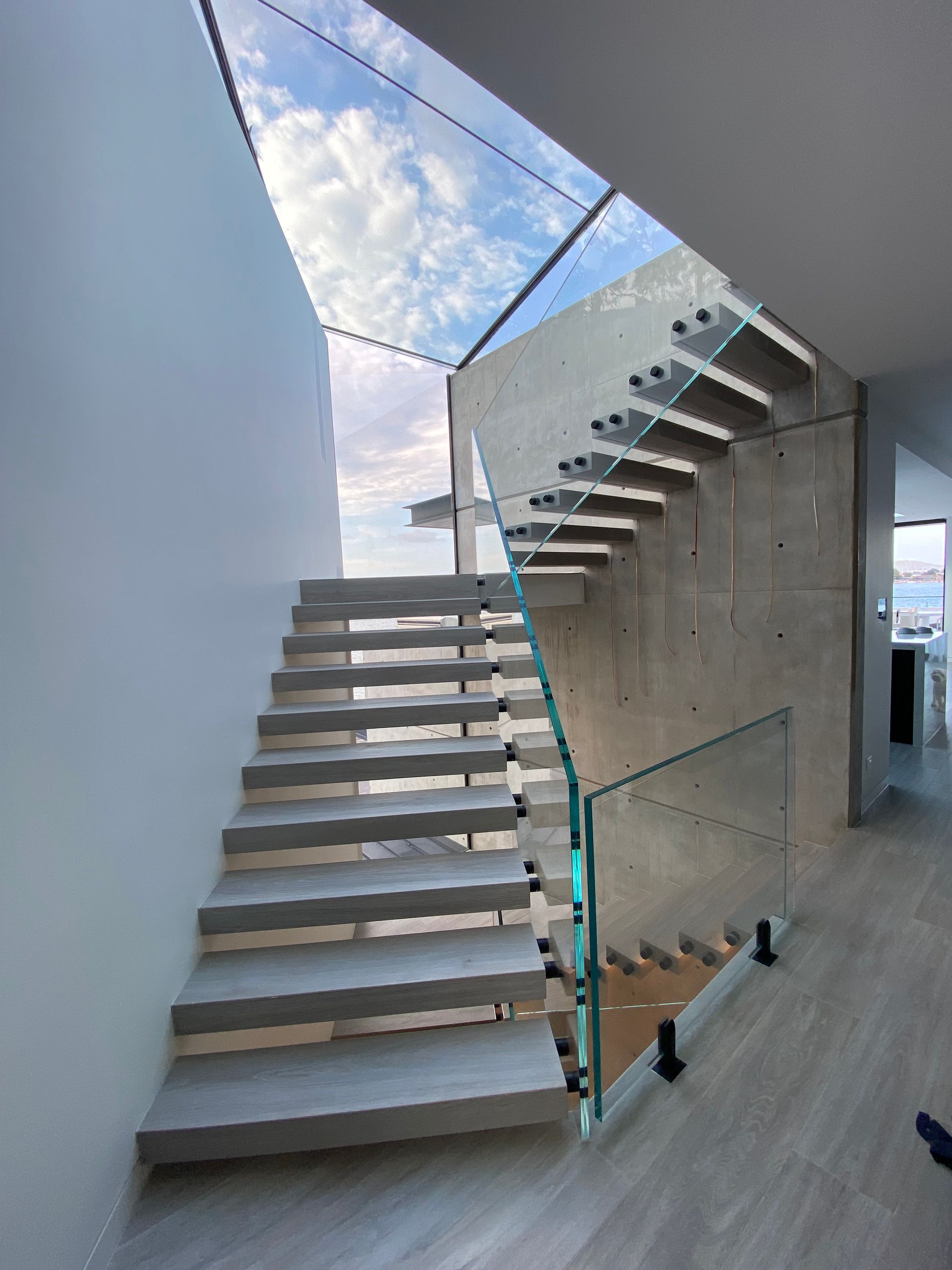 A staircase with a glass railing leading up to the second floor