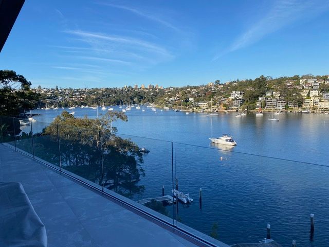 A view of a lake from a balcony with boats in the water.